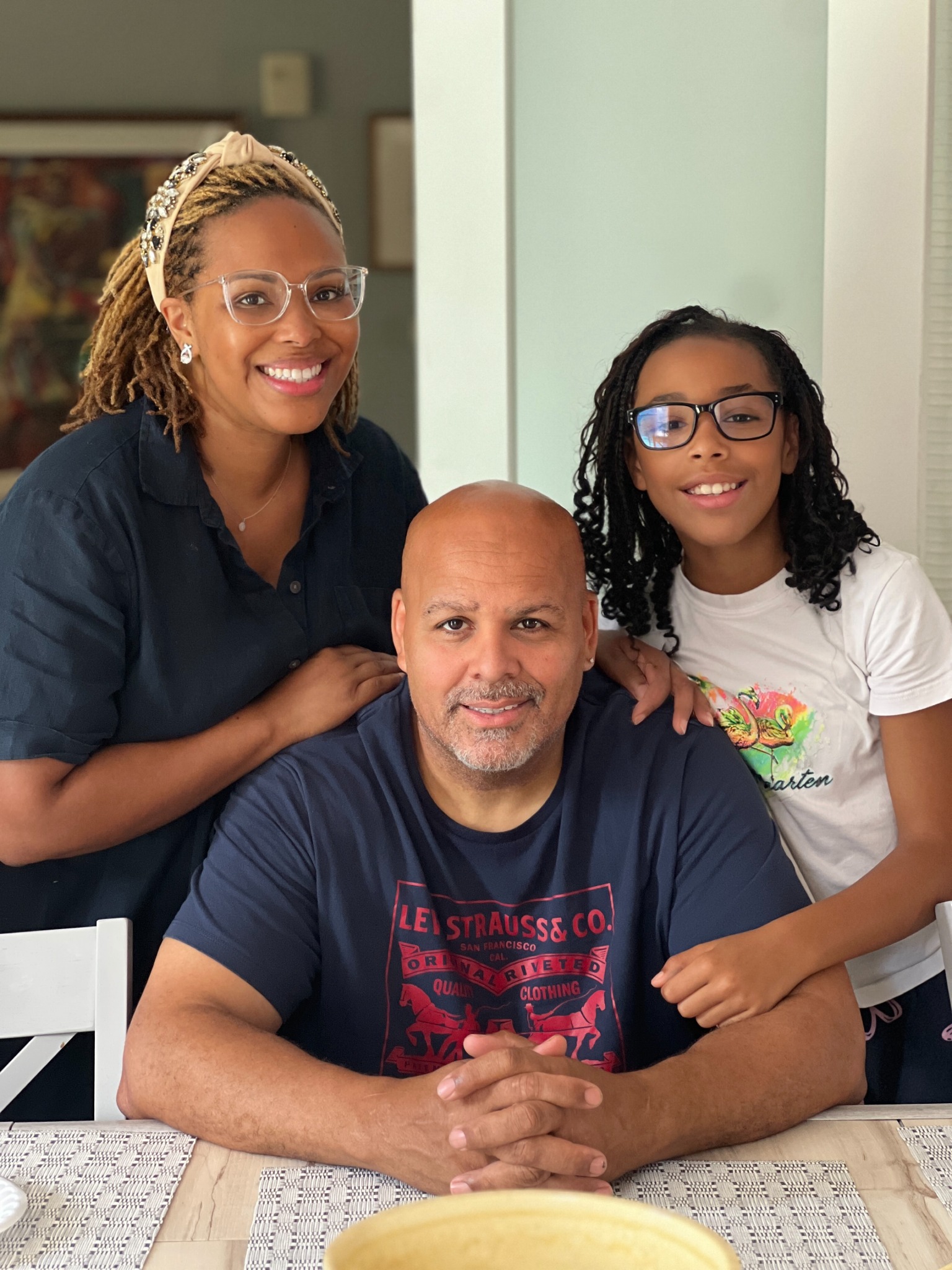 Nikki, Jonathon, and their daughter gathered around the kitchen table